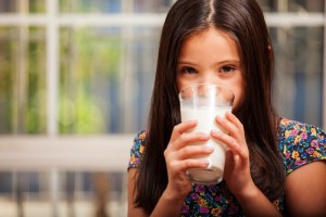 dziewczynka pijąca mleko z szklanki